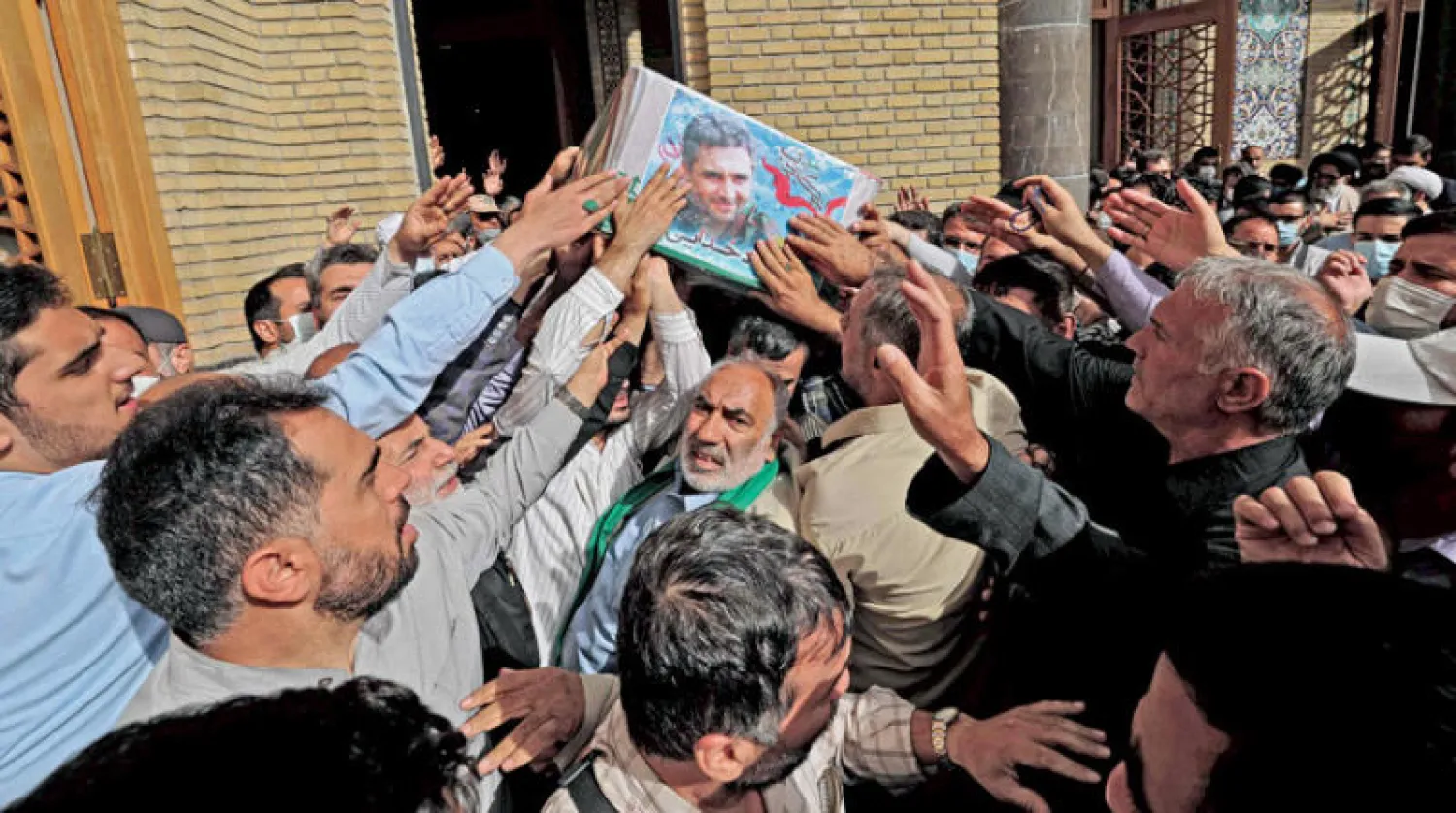 مشيعون يحملون جثة القيادي في «فيلق القدس» بمراسم جنازة رسمية في طهران أمس (أ.ف.ب)