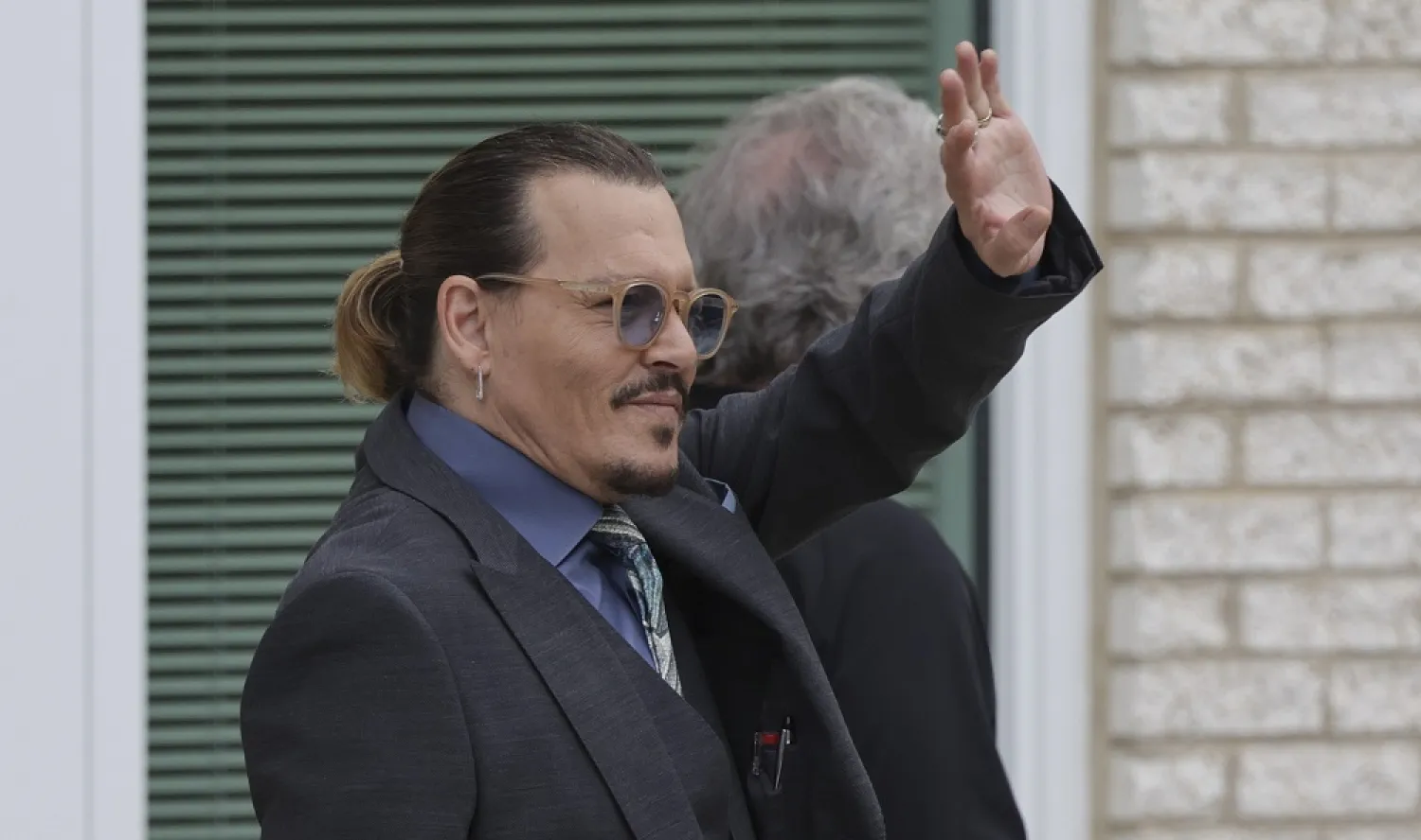 MAY 25: Actor Johnny Depp waves to a fan during a break in his trial at the Fairfax County Courthouse on May 25, 2022 in Fairfax, Virginia. (Getty Images)