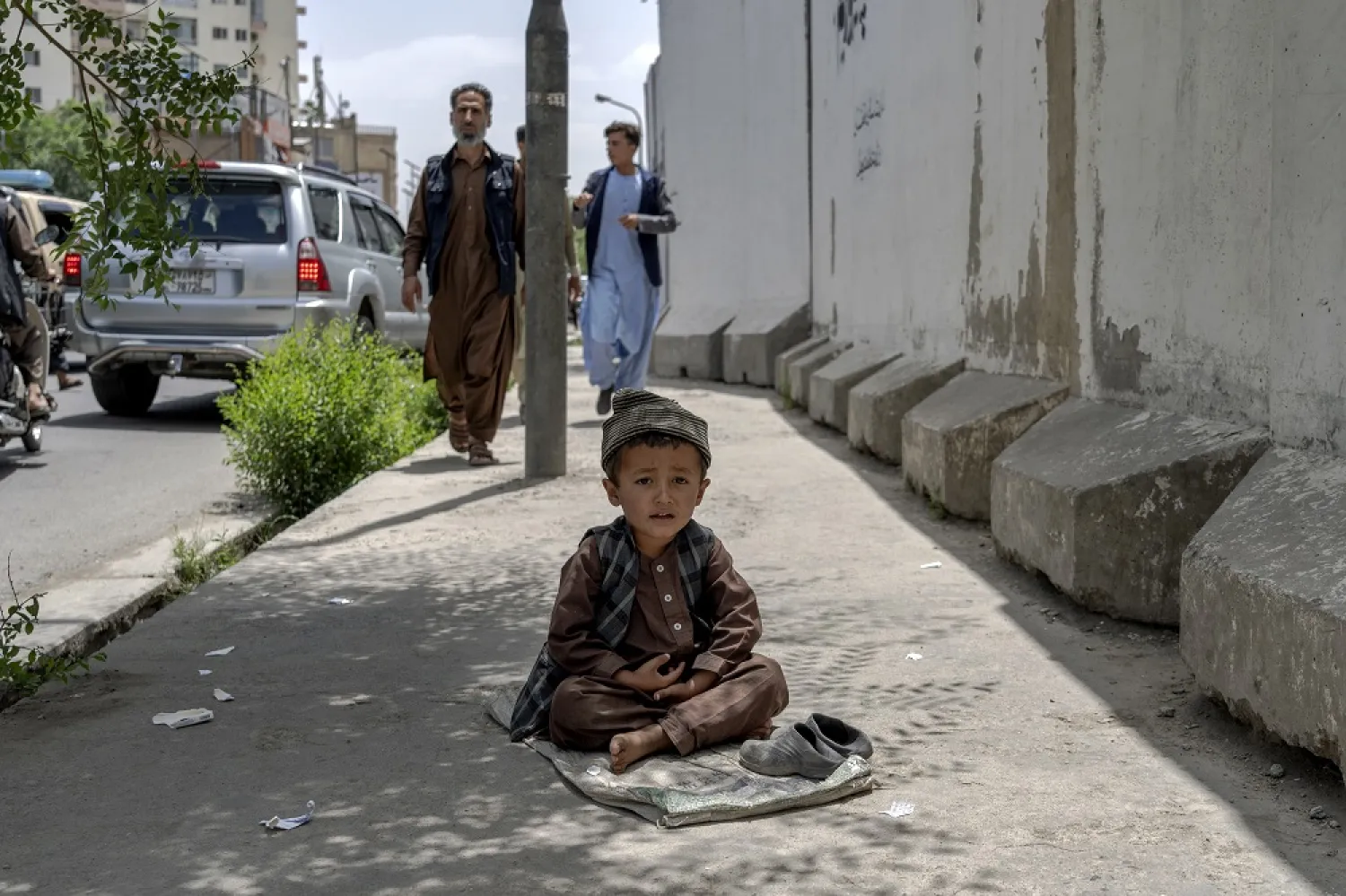 A child begs on a side walk in Kabul, Afghanistan, Sunday, May 22, 2022. (AP)
