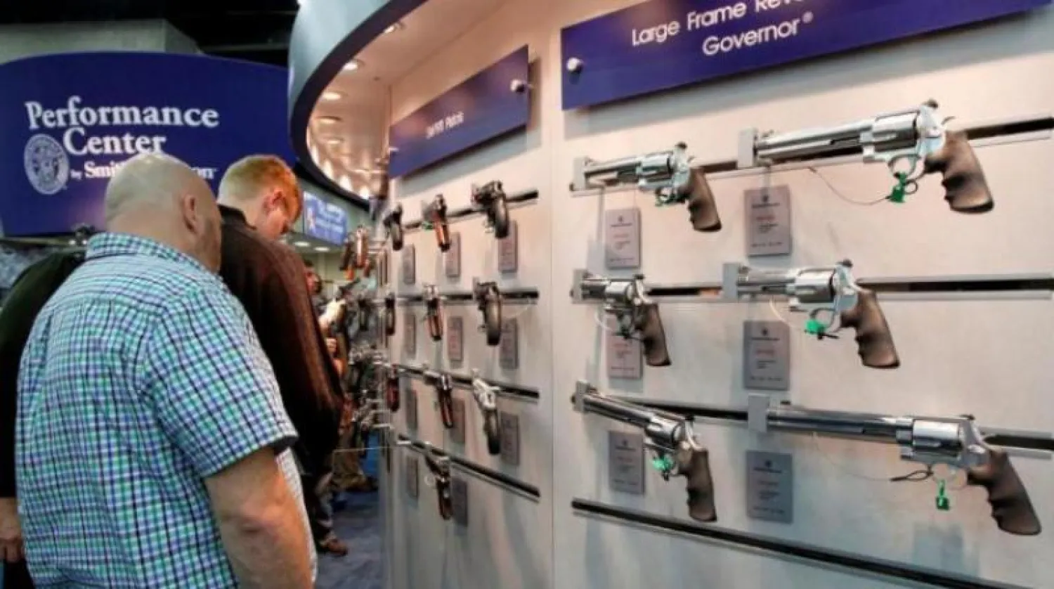 أميركيون ينظرون إلى بنادق خلال أحد المعارض السنوية لـ«الجمعية الوطنية للبنادق» (أرشيفية - رويترز)