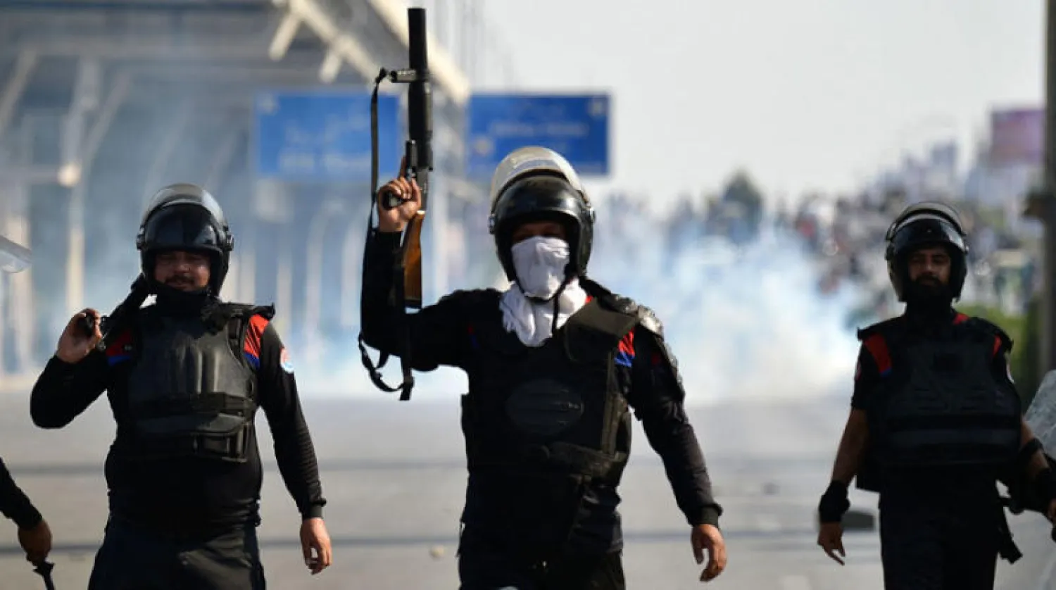 رجال شرطة باكستانيون بعد إطلاق قذائف الغاز المسيل للدموع على أنصار رئيس الوزراء الباكستاني السابق عمران خان خلال مسيرة احتجاجية في روالبندي اول من أمس "  ا ف ب "