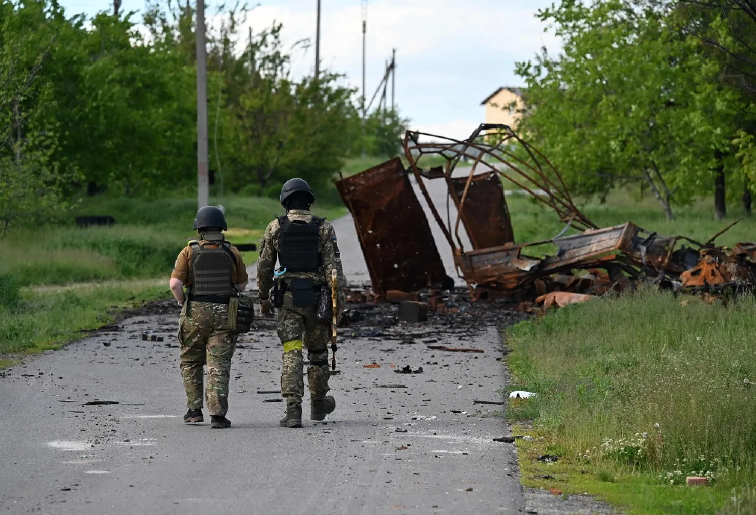 Ukrainian servicemen walk next to a destroyed military in the village of Rus'ka Lozova, north of Kharkiv, on May 28, 2022, amid Russian invasion of Ukraine. (AFP) 