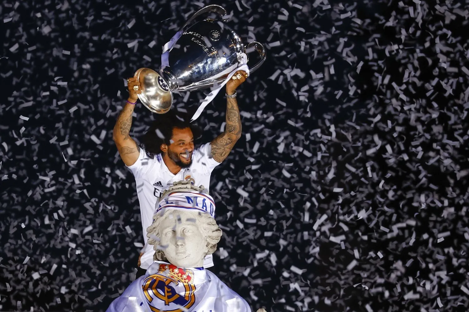 Real Madrid's captain Marcelo lifts the trophy on top of the Cibeles fountain during celebrations for Real Madrid's 14th UEFA Champions League title in Madrid, Spain, 29 May 2022. (EPA)