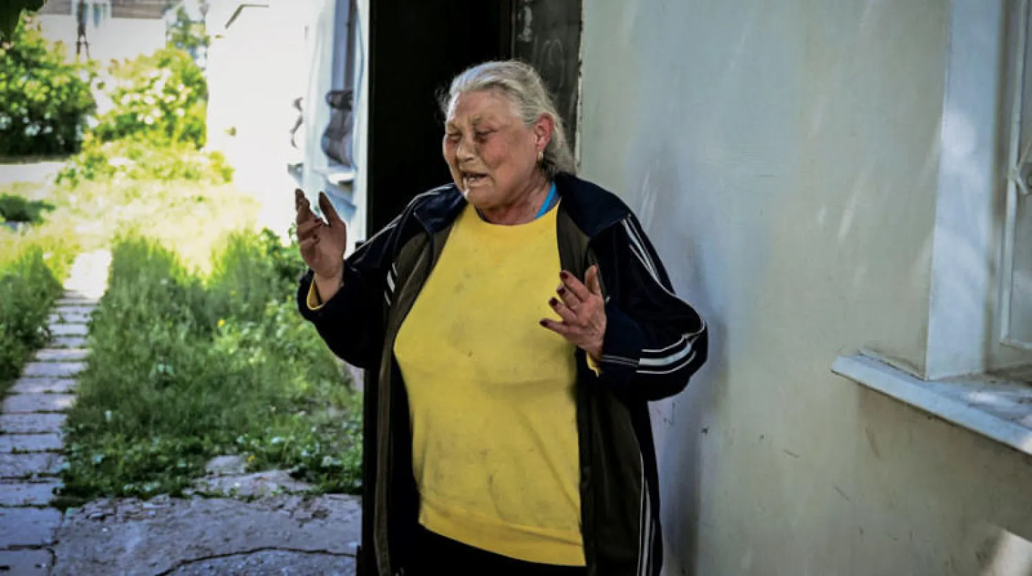 أوكرانية مسنّة تبدو متأثرة بعد استهداف منزلها في مدينة ليسيتسانك في إقليم دونباس أمس (أ.ف.ب)