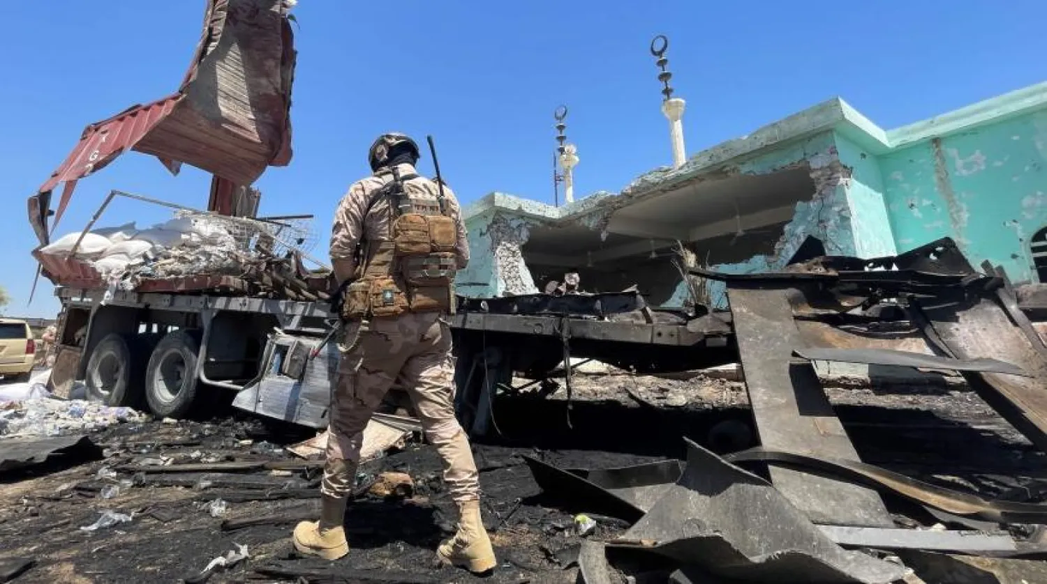 File Photo: A member of the Iraqi security forces walks past a destroyed vehicle that was carrying rockets amid sacks of flour, in the district of al-Baghdadi in al-Anbar province on July 8, 2021. (AFP Photo)
