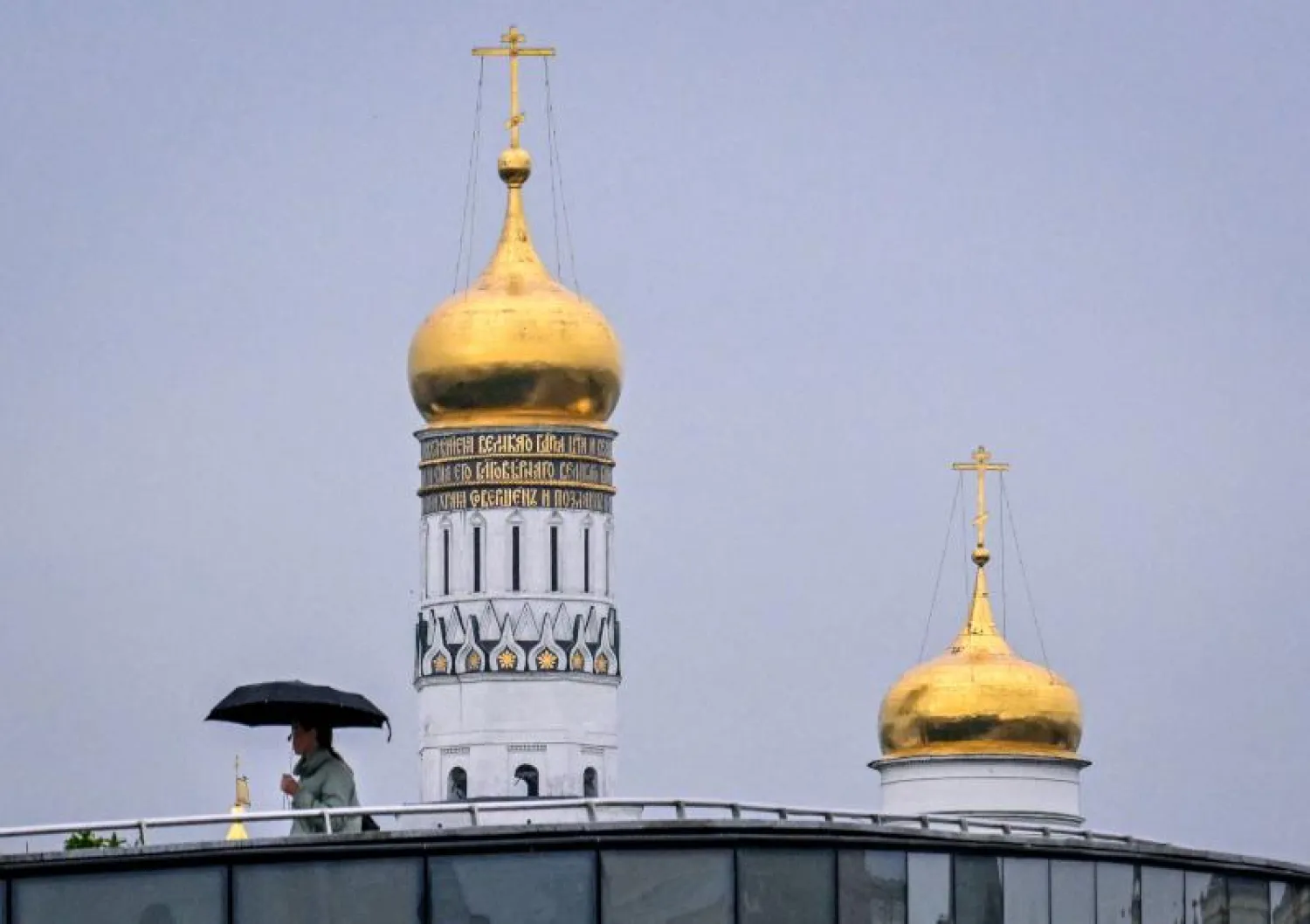 رجل يمر قرب الكرملين في موسكو (أ.ف.ب)