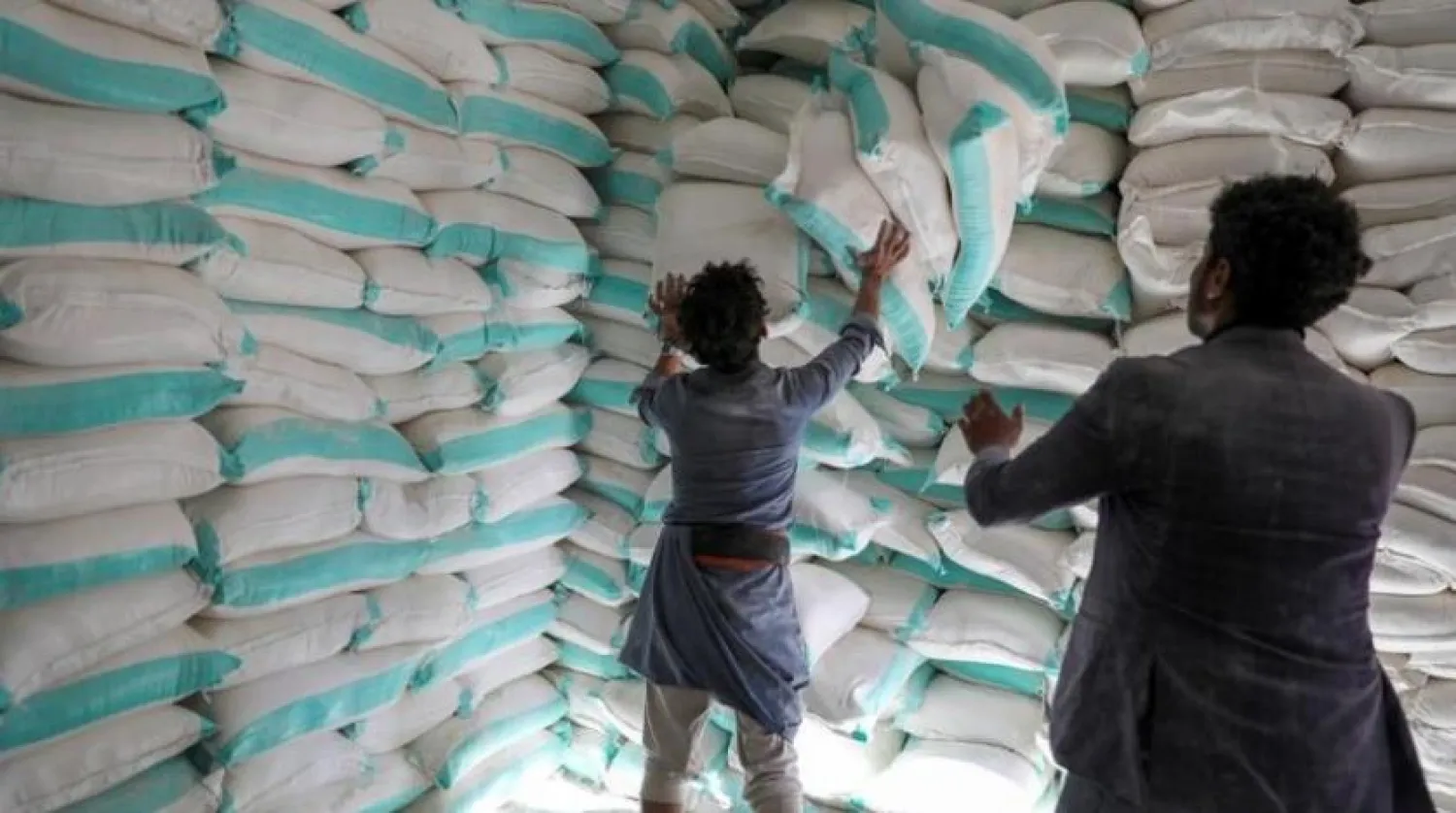 Workers handle sacks of wheat flour at a World Food Program food aid distribution center in Sanaa, Yemen (File photo: Reuters)

