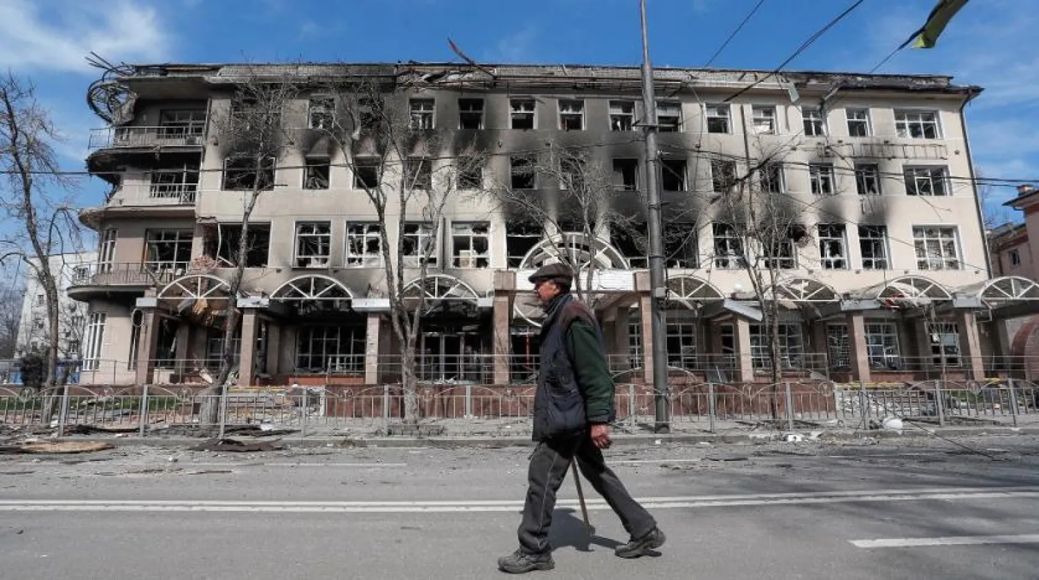 A resident walks near a building destroyed in the course of the Ukraine-Russia conflict, in the southern port city of Mariupol, Ukraine April 10, 2022. (Reuters)
