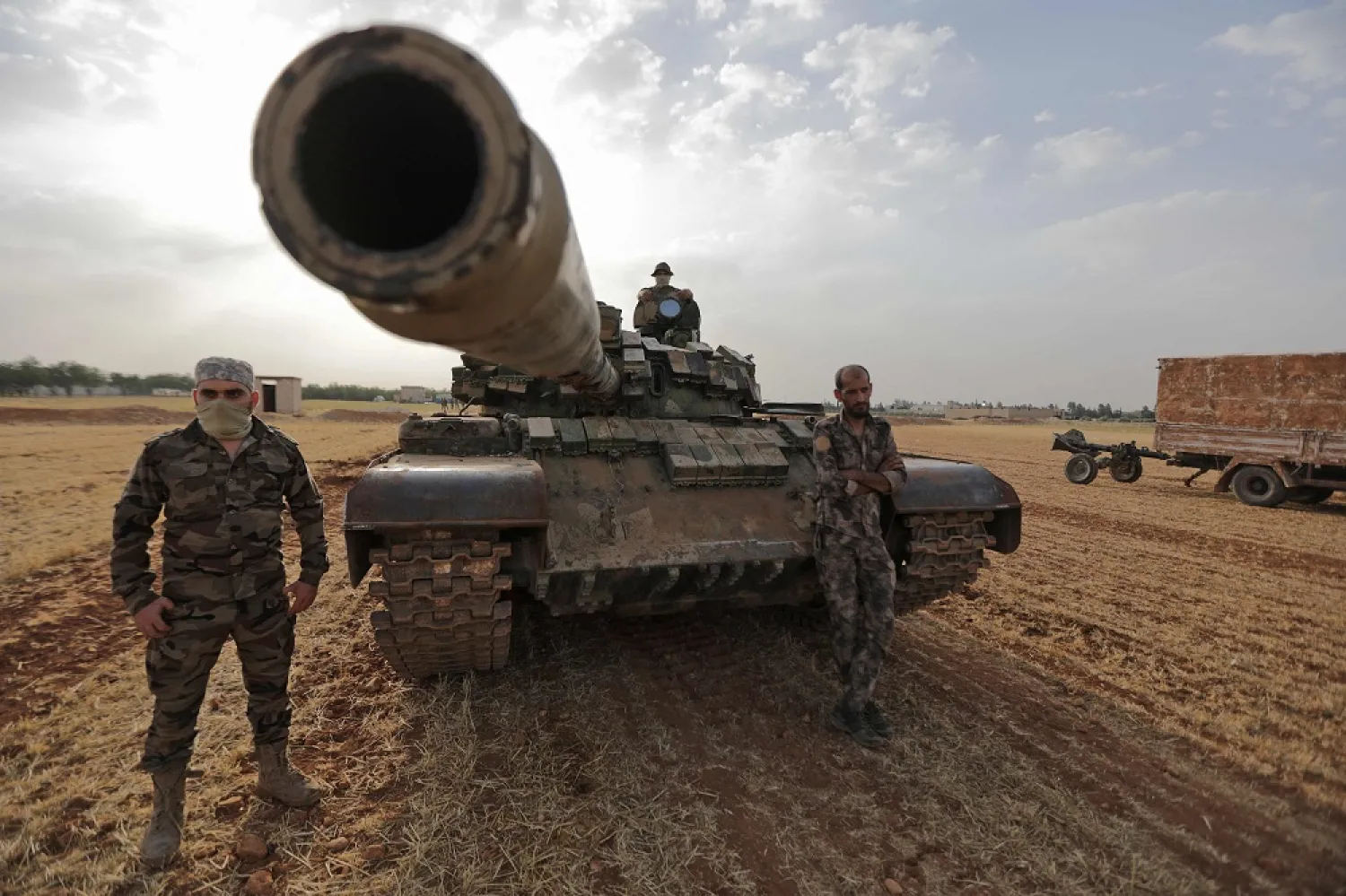 Turkey-backed Syrian fighters gather around a tank during a military exercise in the countryside of the northern city of Manbij, on June 2, 2022. (AFP)