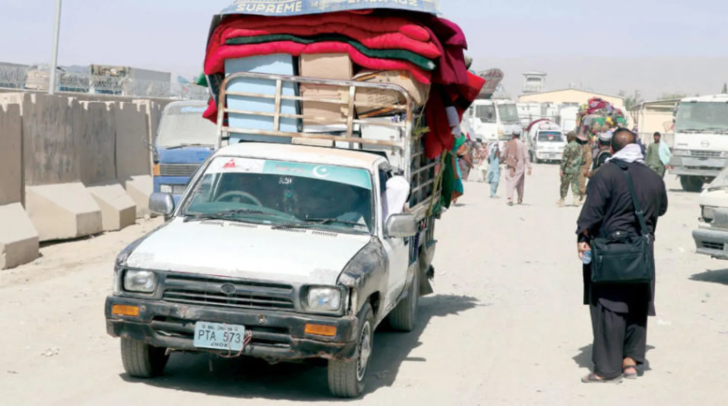 عائلات أفغانية تعبر إلى أفغانستان من باكستان عبر معبر سبين بولداك الحدودي بالقرب من قندهار (إ.ب.أ)