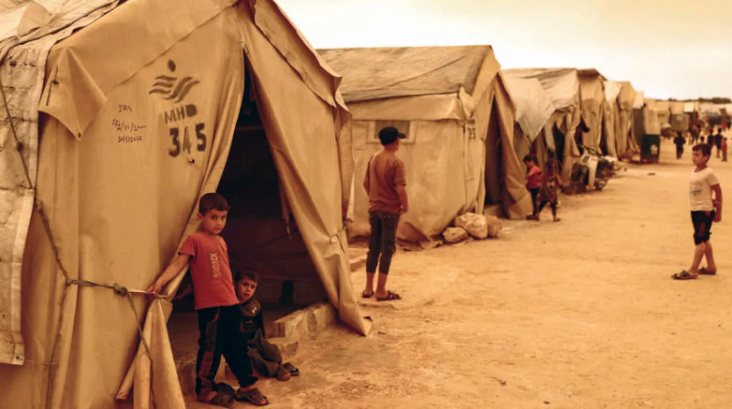 مخيم للنازحين السوريين في ظل عاصفة ترابية بريف محافظة إدلب السورية أول من أمس (د.ب.أ)