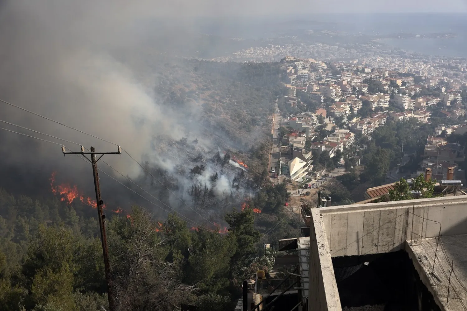 Flames burn trees on a hill during a wildfire in Voula suburb, in southern Athens, Greece, Saturday, June 4, 2022. (AP)
