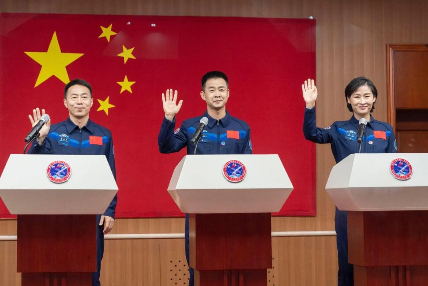 In this photo released by Xinhua News Agency, Chinese astronauts from left Cai Xuzhe, Chen Dong and Liu Yang, right, wave as they attend a press conference for the upcoming Shenzhou-14 mission at the Jiuquan Satellite Launch Center in northwestern China on Saturday, June 4, 2022. (AP)