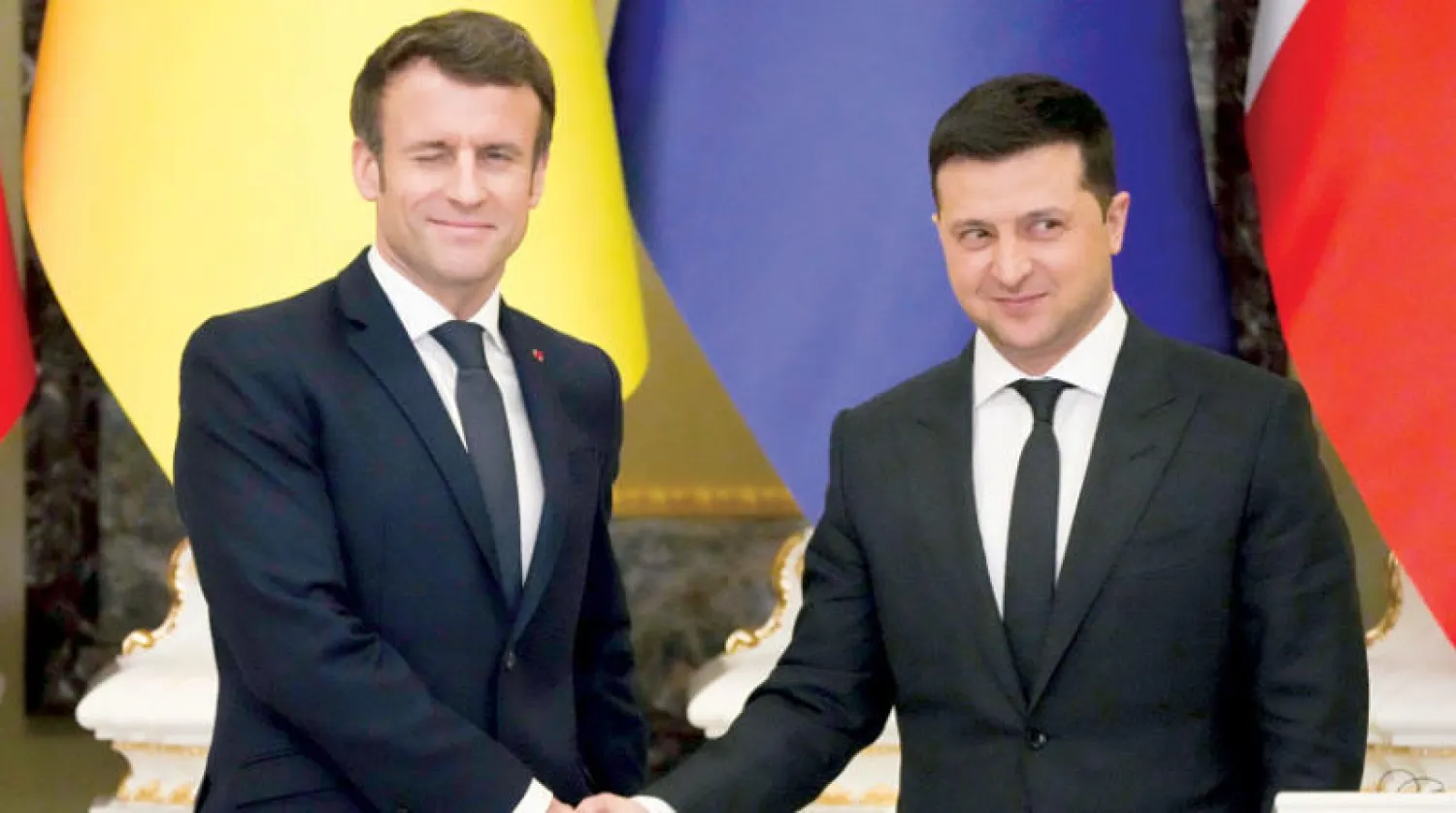 ماكرون يصافح زيلينسكي لدى زيارته كييف في 8 فبراير (أ.ب)