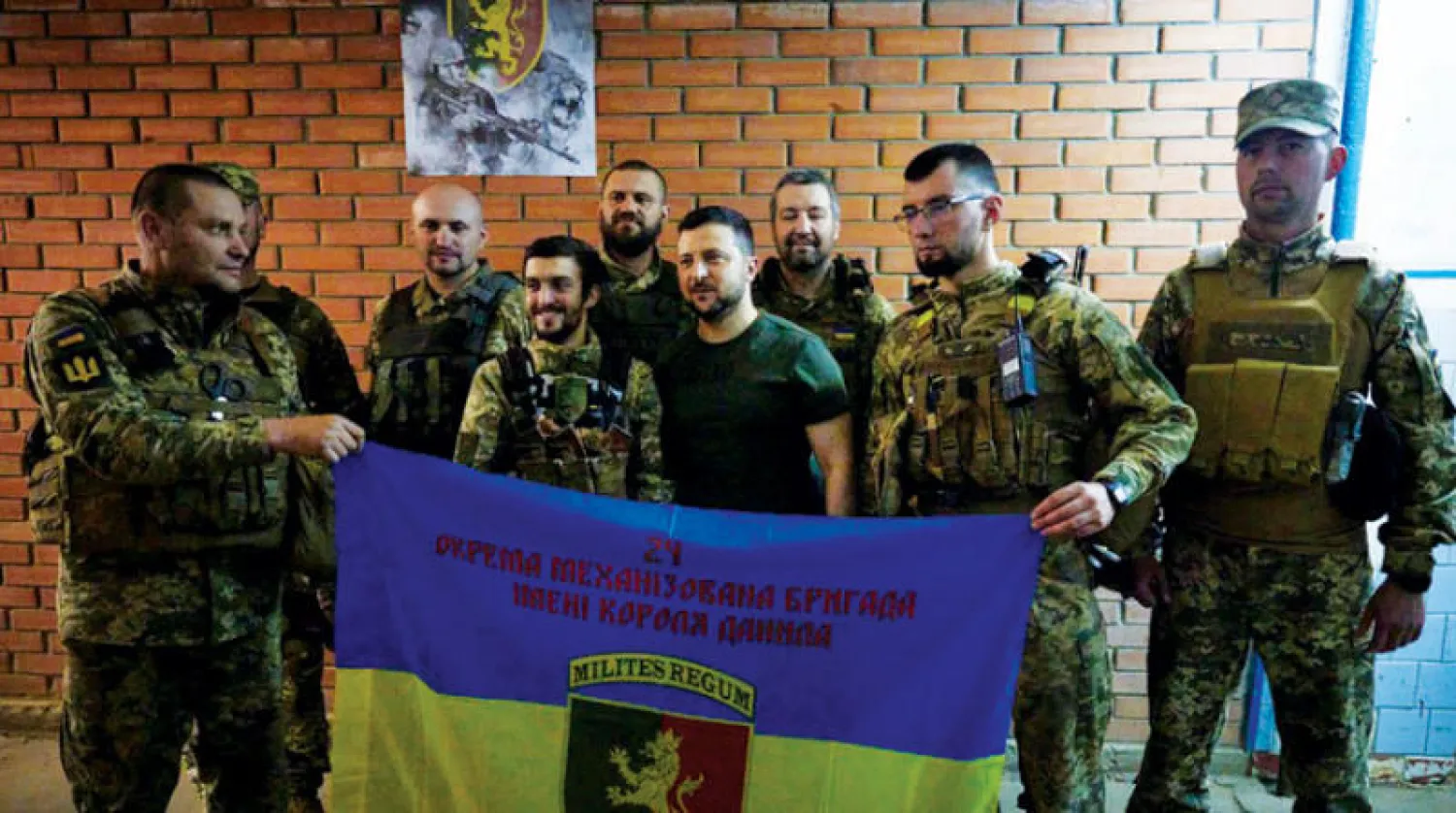 زيلينسكي مع جنود أوكرانيين خلال زيارته لمنطقتي باخموت (دونيتسك) وليسيتشانسك (لوغانسك) أمس (أ.ف.ب)