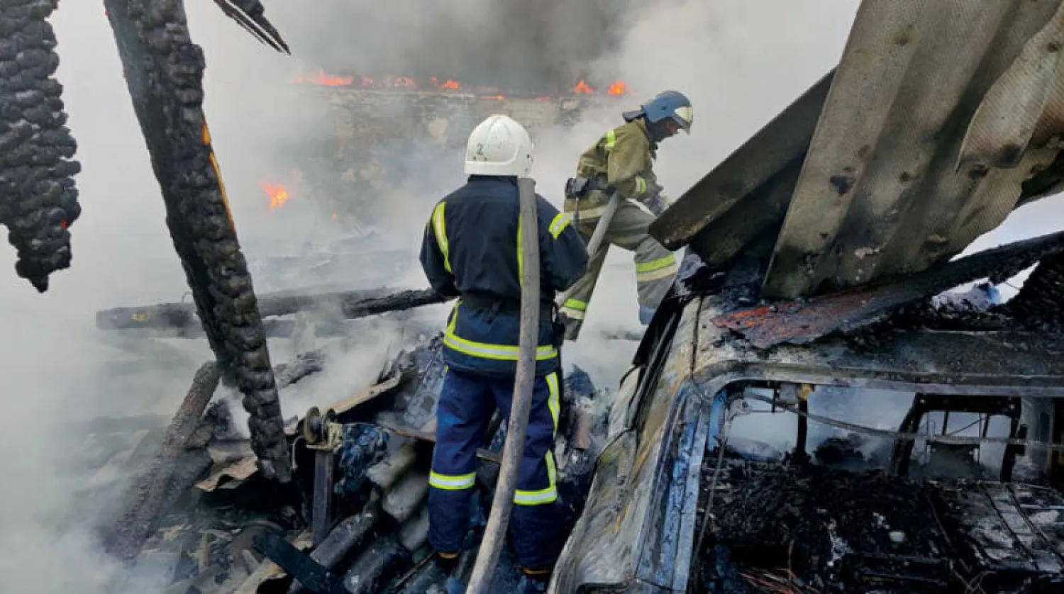 قوات الدفاع المدني تطفئ النيران المشتعلة بمستودع طاله القصف في دونيتسك أمس (رويترز)