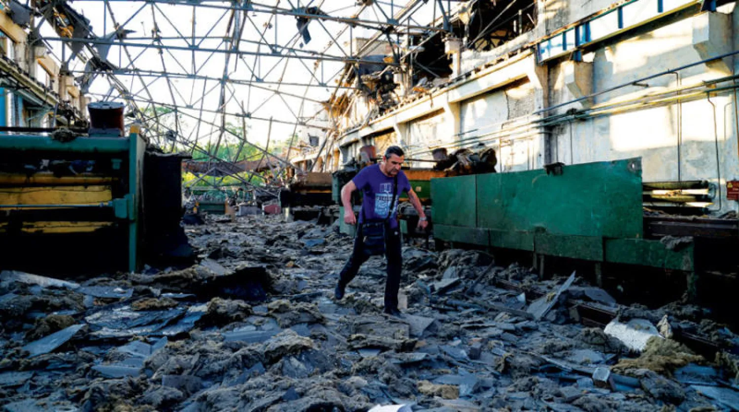 صاحب ورشة لتصليح السيارات في كييف يعاين أمس الدمار الذي خلفته ضربة صاروخية روسية أول من أمس (رويترز)