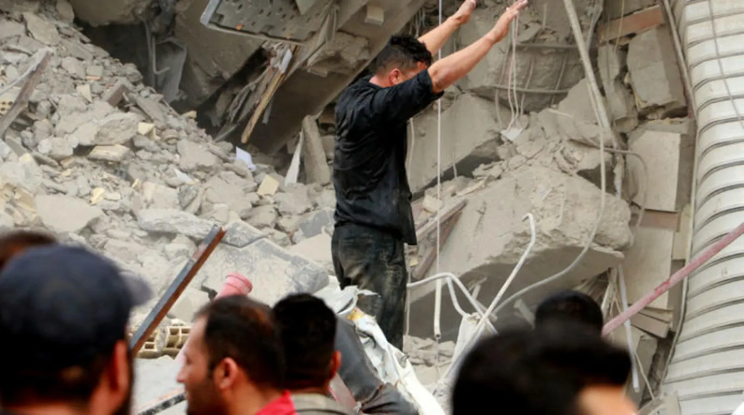 فرق الإنقاذ في موقع انهيار مبنى تجاري في عبادان جنوب غرب إيران 23 مايو 2022 (رويترز)