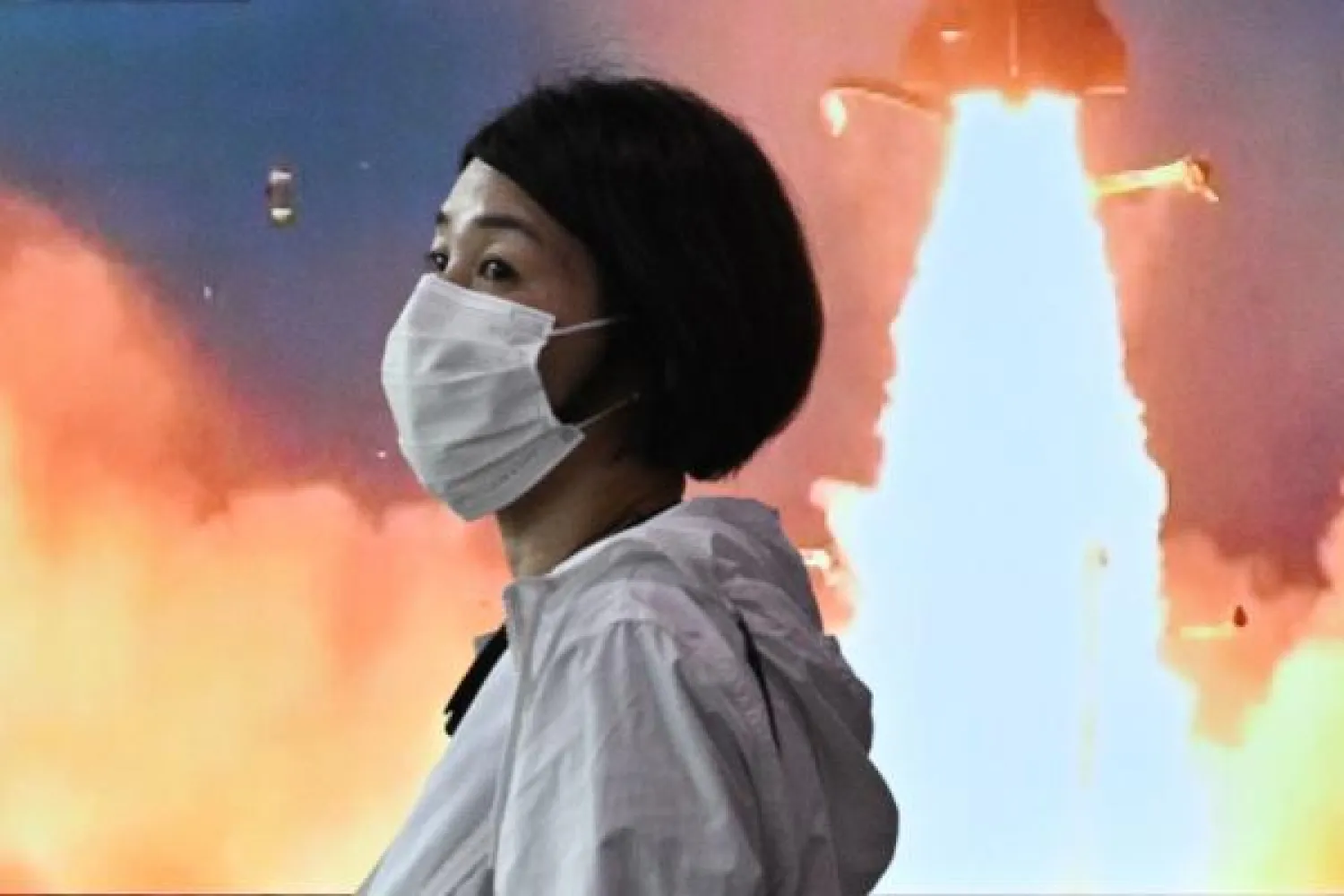 امرأة تمر بجانب شاشة في سيول تعرض صوراً عن تجاب كوريا الشمالية الصاروخية (ا.ف.ب)