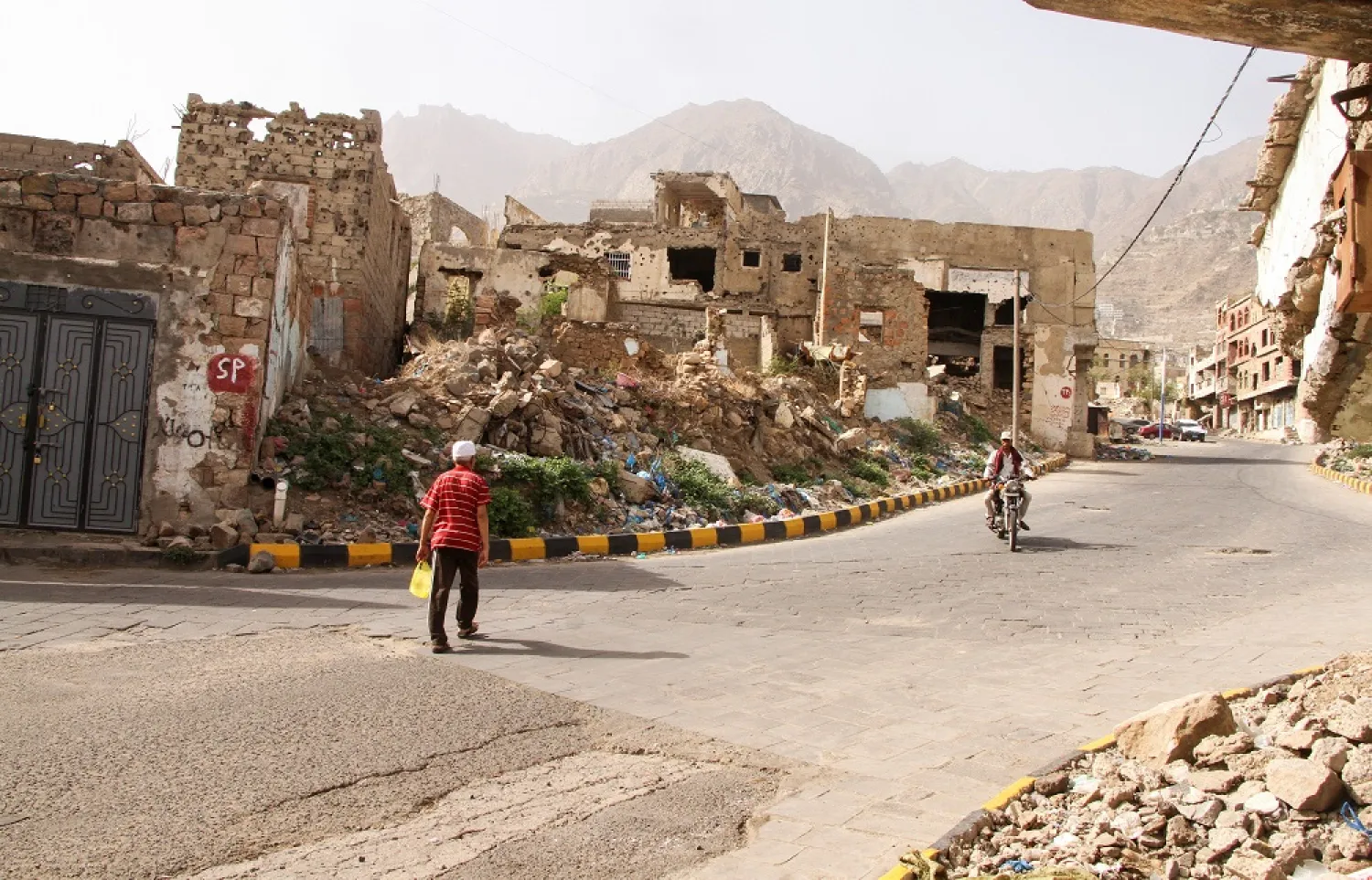 A man walks past buildings damaged by war in Taiz, Yemen May 20, 2022. Picture taken May 20, 2022. (Reuters)