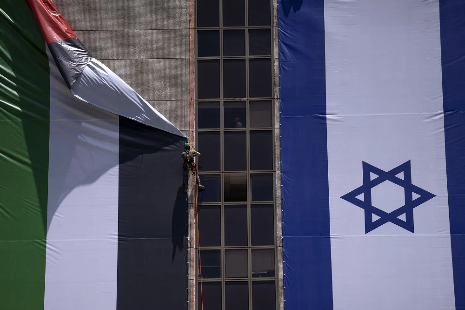 A Palestinian flag is removed from a building by Israeli authorities after being put up by an advocacy group that promotes coexistence between Palestinians and Israelis, in Ramat Gan, Israel, Wednesday, June 1, 2022. (AP)