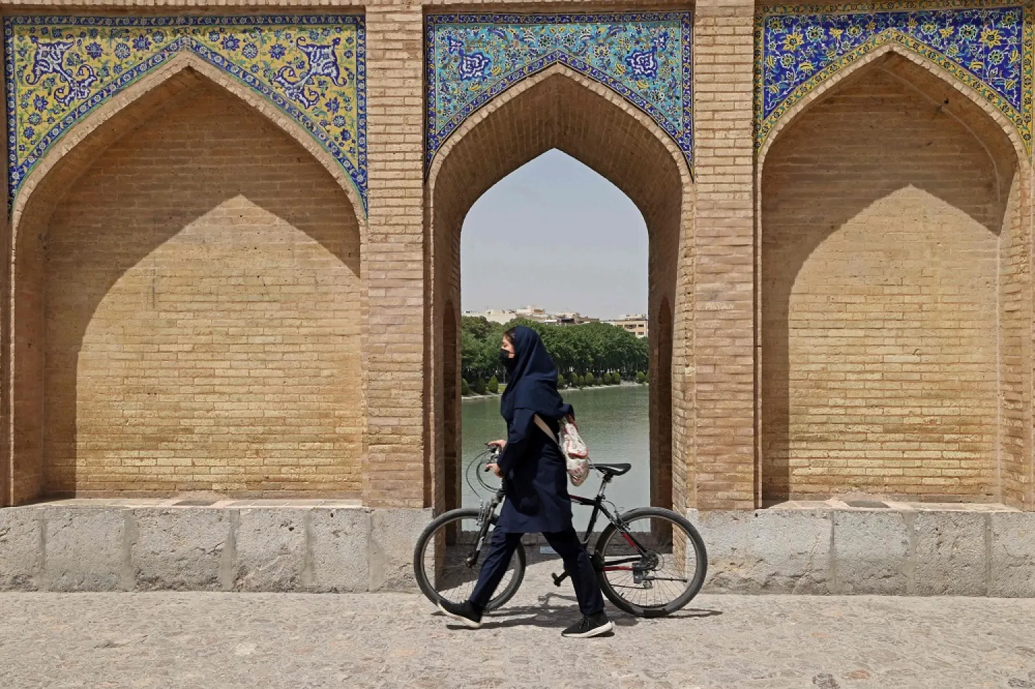 An Iranian woman crosses the iconic Khaju Bridge over the Zayandeh Rud river in Isfahan, on May 16, 2022 . (AFP) 