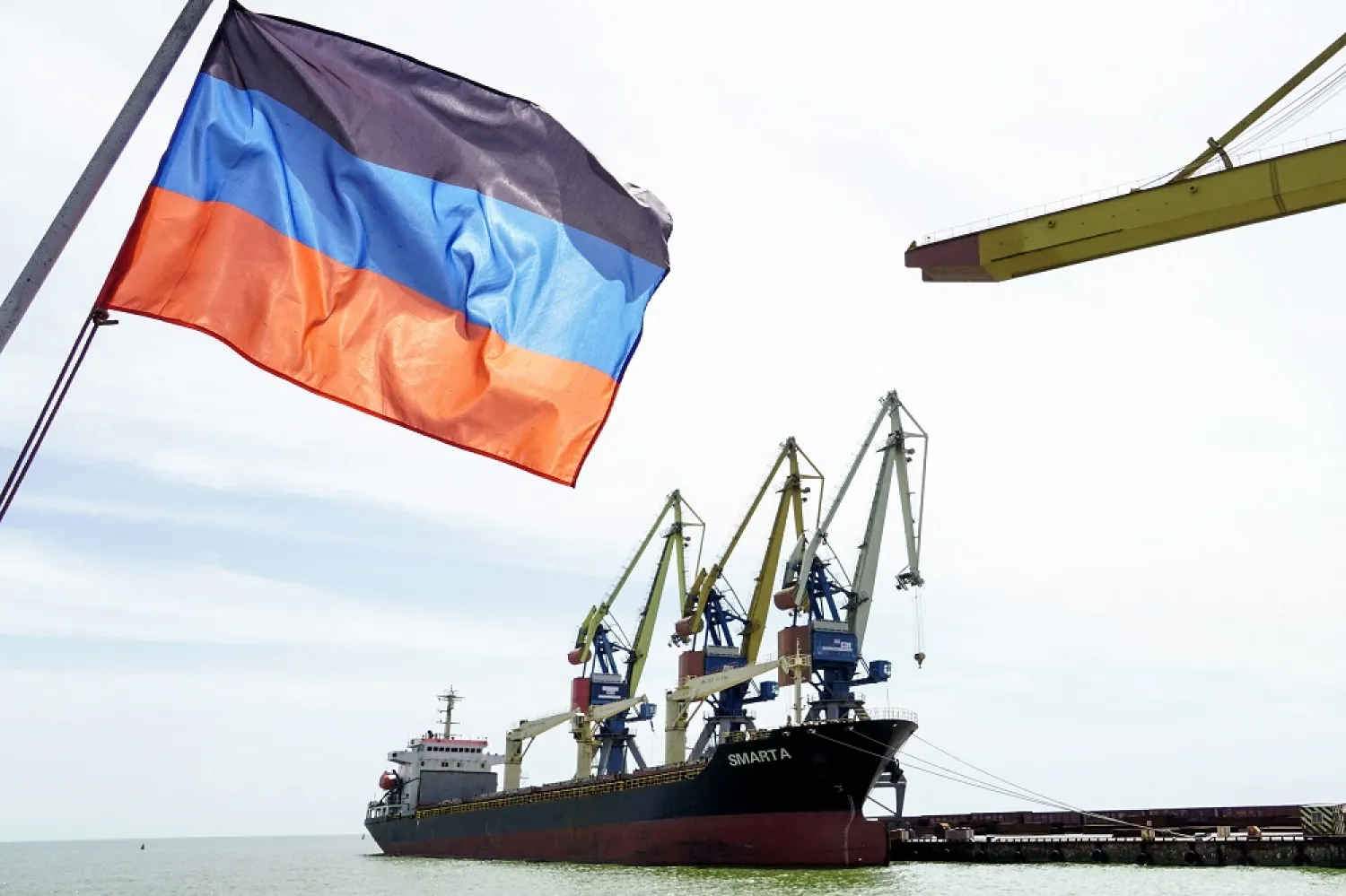 A photograph shows a Donetsk People Republic's flag in front of a ship in the harbour of Mariupol on June 3, 2022, on the 100th day of the Russian invasion of Ukraine. (AFP)