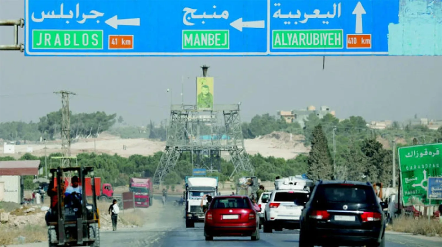 لوحة إرشادية تدل على الطريق المؤدية إلى منبج وهي هدف رئيسي في العملية العسكرية التركية المرتقبة شمال سوريا (رويترز)