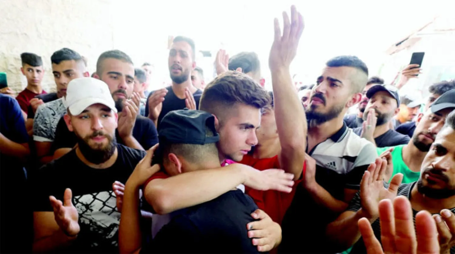 فلسطينيون في مستشفى في الخليل بعد قتل القوات الإسرائيلية محمود أبو عيهور في الضفة امس (رويترز)