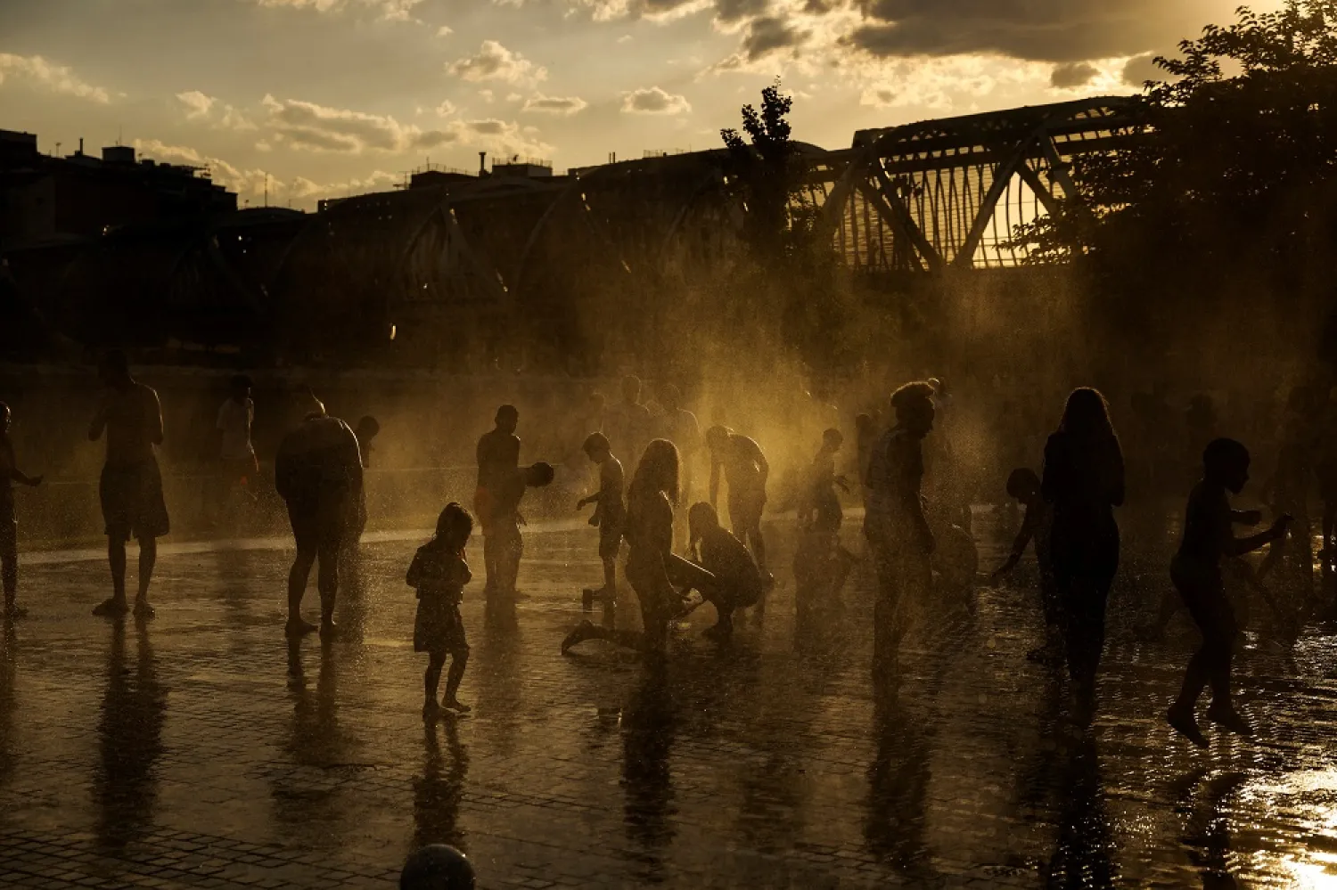 People cool off at a fountain in Madrid Rio Park during the first heatwave of the year in Madrid, Spain, June 11, 2022. (Reuters)
