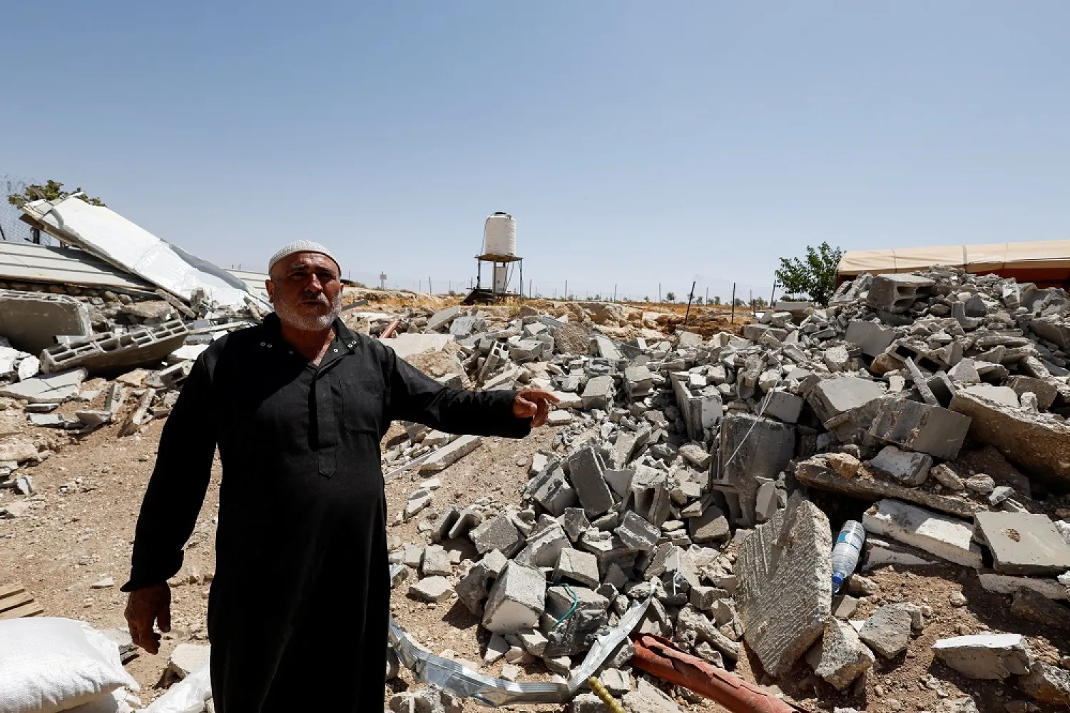 Palestinian Mahmoud Najajreh points at his demolished house, in Masafer Yatta, South of Hebron, in the Israeli-occupied West Bank, May 31, 2022. Picture taken May 31,2022. (Reuters)