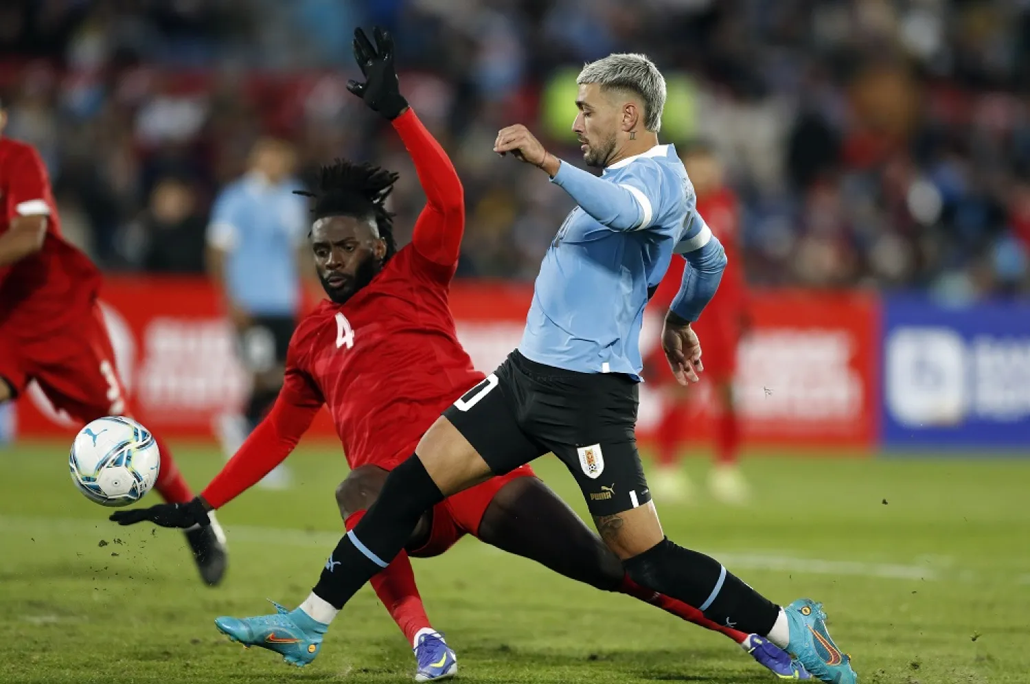 Uruguay's Giorgian de Arrascaeta, right, fights for the ball with Panama's Manuel Gamboa during a friendly match at Centenario Stadium in Montevideo, Uruguay, Saturday, June 11, 2022. (AP)