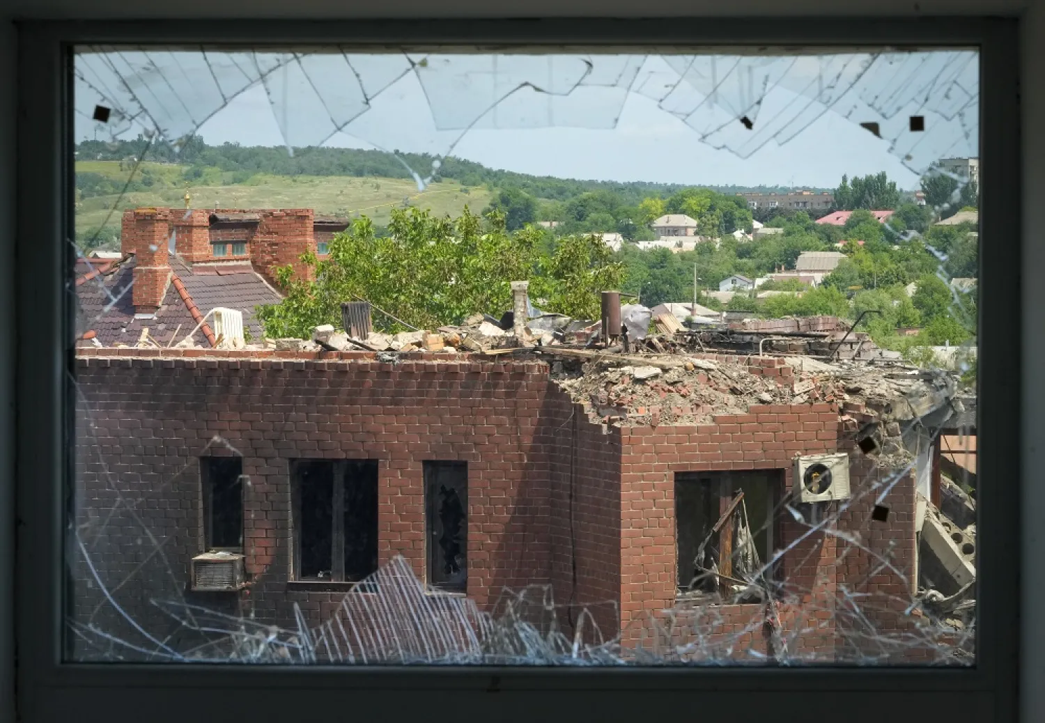 A heavily damaged house following Russian night shelling is seen through a broken window, in the town of Bakhmut, Donetsk region, Ukraine, Monday, June 13, 2022. (AP)