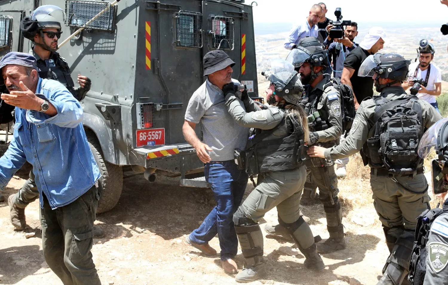 Palestinian protesters scuffle with Israeli soldiers, during a protest in the village of Tarqumiyah near the West Bank city of Hebron, 11 June 2022. (EPA)