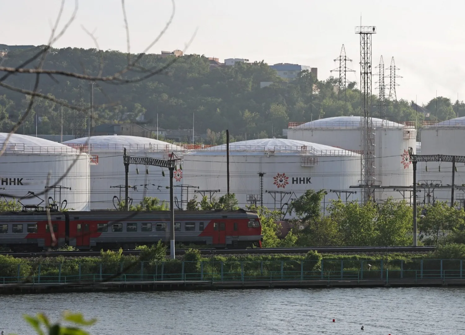 A train moves past oil tanks of the NNK-Primornefteproduct petroleum depot in the far eastern port of Vladivostok, Russia June 11, 2022. (Reuters)