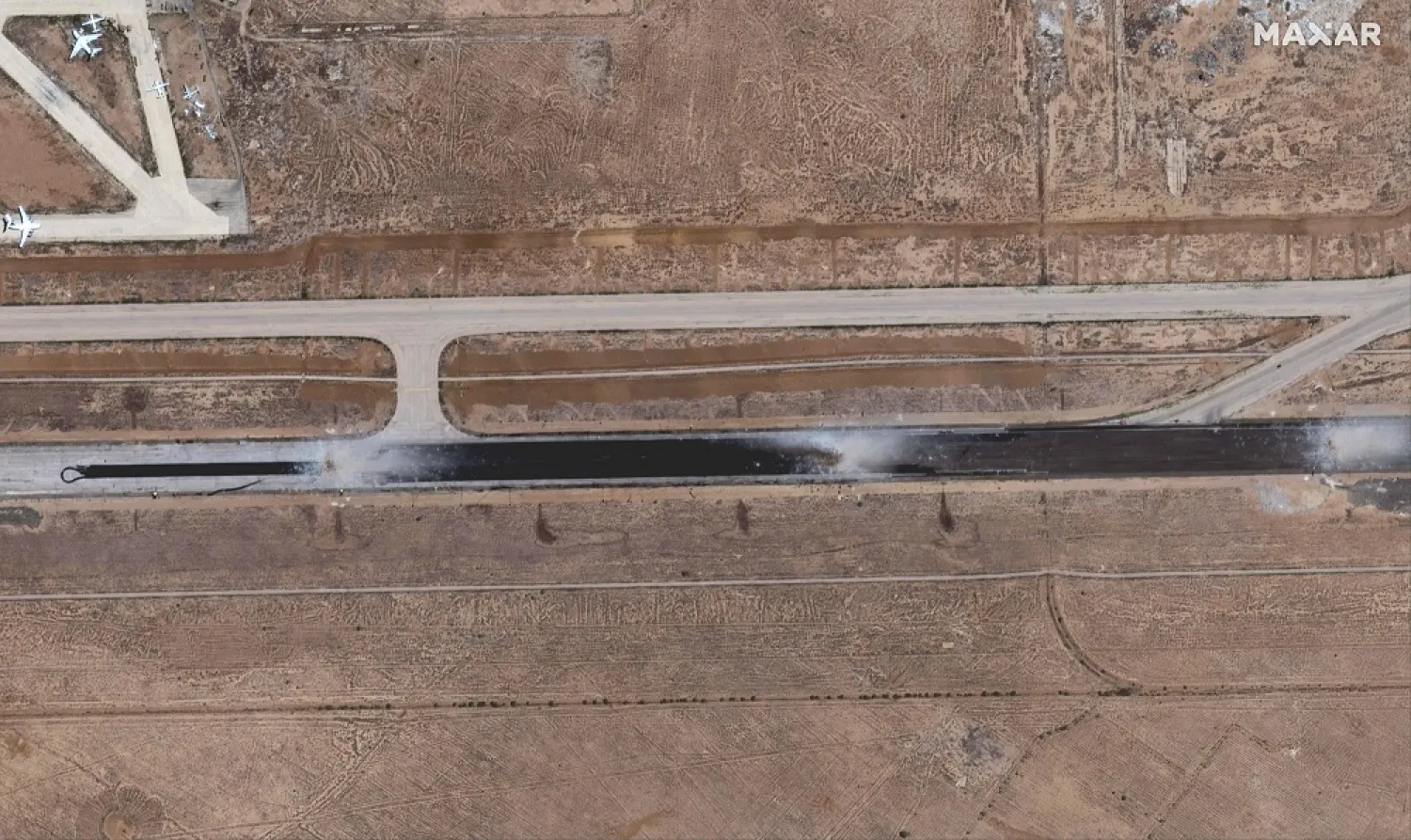 This handout satellite image released by Maxar Technologies, shows damage to a runway at Damascus International Airport on the southeastern outskirts of Syria's capital on June 10, 2022. (Photo by Satellite image 2022 Maxar Technologies / AFP)