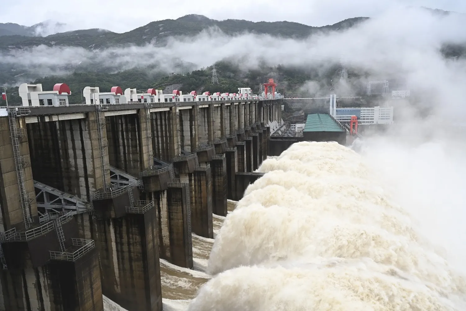 In this photo released by China's Xinhua News Agency, water flows out from a gate of the Shuikou Hydropower Station in southeastern China's Fujian Province, Monday, June 13, 2022. (Xinhua via AP) 