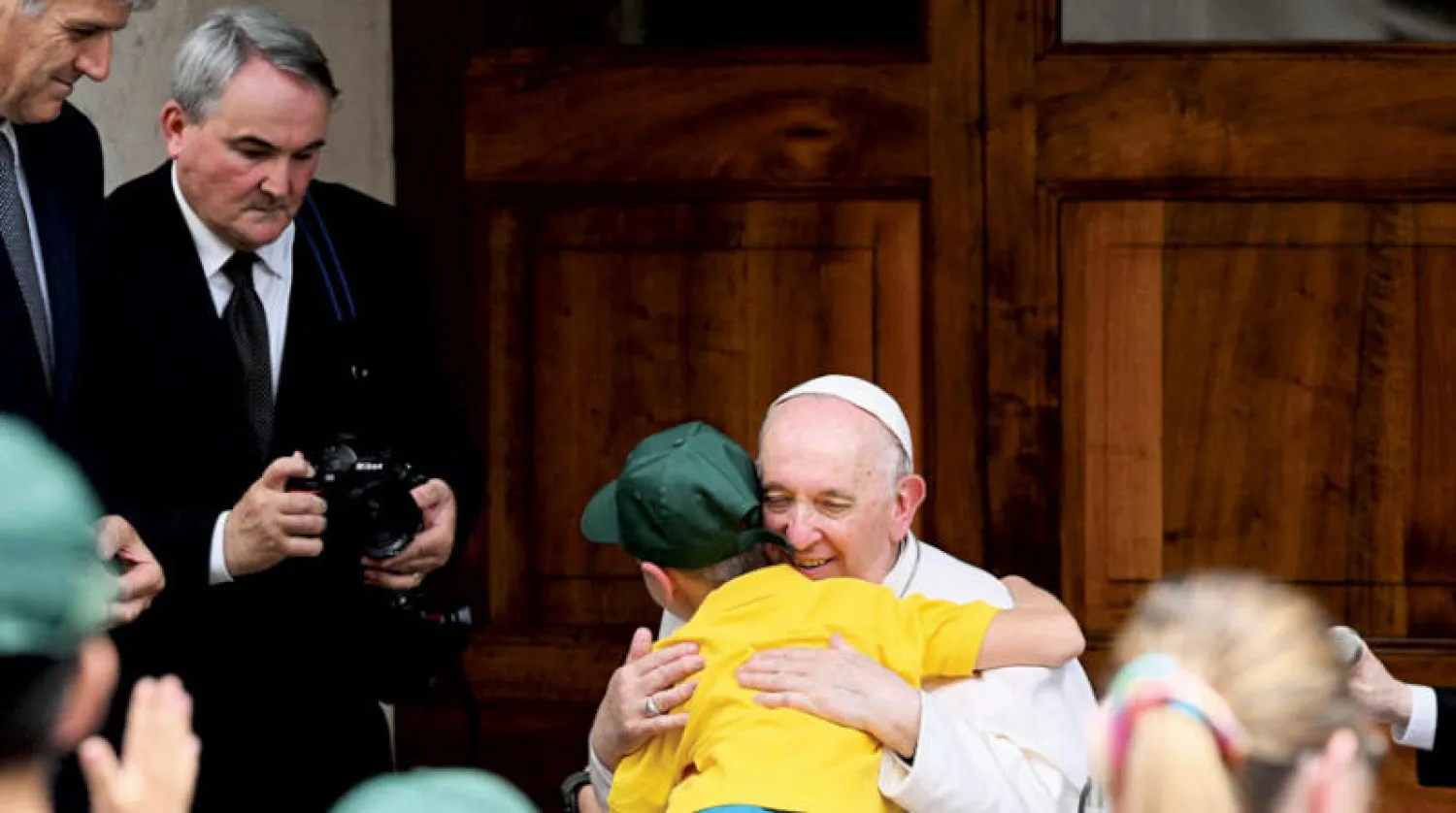 البابا يحتضن طفلاً لاجئاً من أوكرانيا في 4 يونيو (أ.ف.ب)