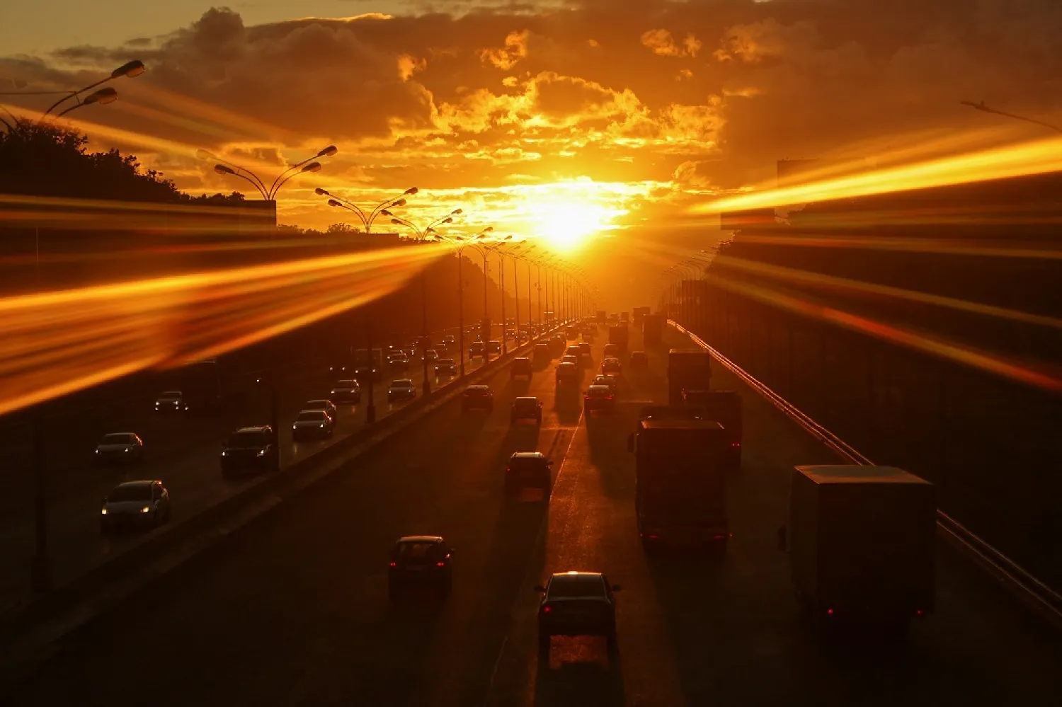 Cars drive along a highway during sunset in Moscow, Russia June 15, 2022. Picture taken through the window. (Reuters)