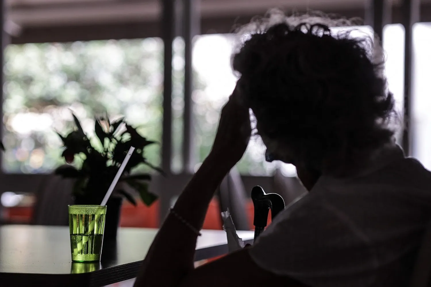 A woman drinks a glass of water in the Magendie autonomous residence in Bordeaux, southwestern France, on June 16, 2022 during a heat wave in France. (AFP)