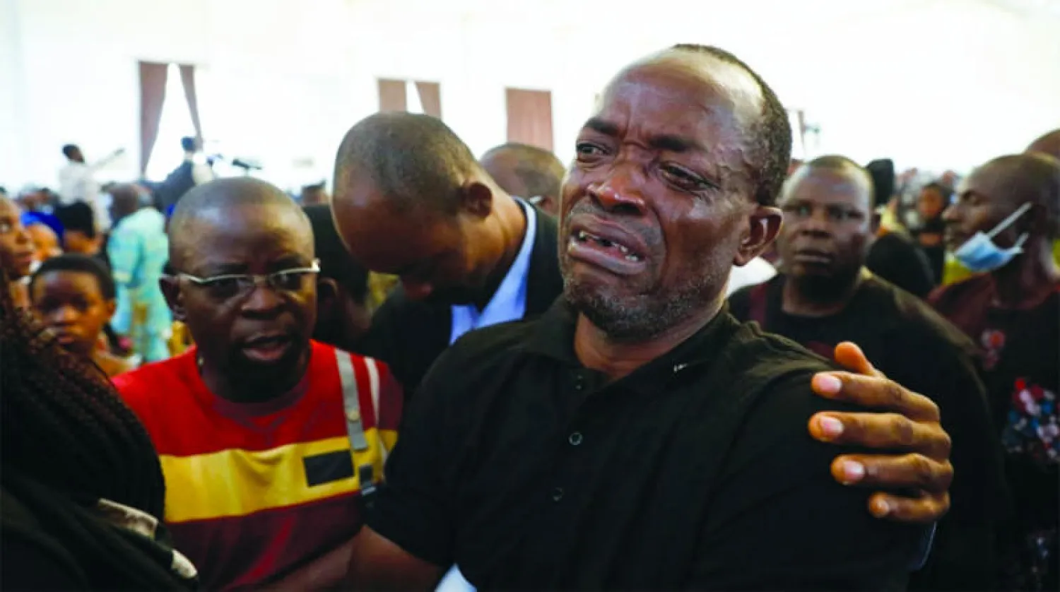 رجل يبكي أثناء حضوره حفل تأبين جماعي لضحايا قُتلوا في هجوم شنه مسلحون خلال قداس يوم الأحد في كنيسة القديس فرنسيس الكاثوليكية في أوو بنيجيريا (رويترز)