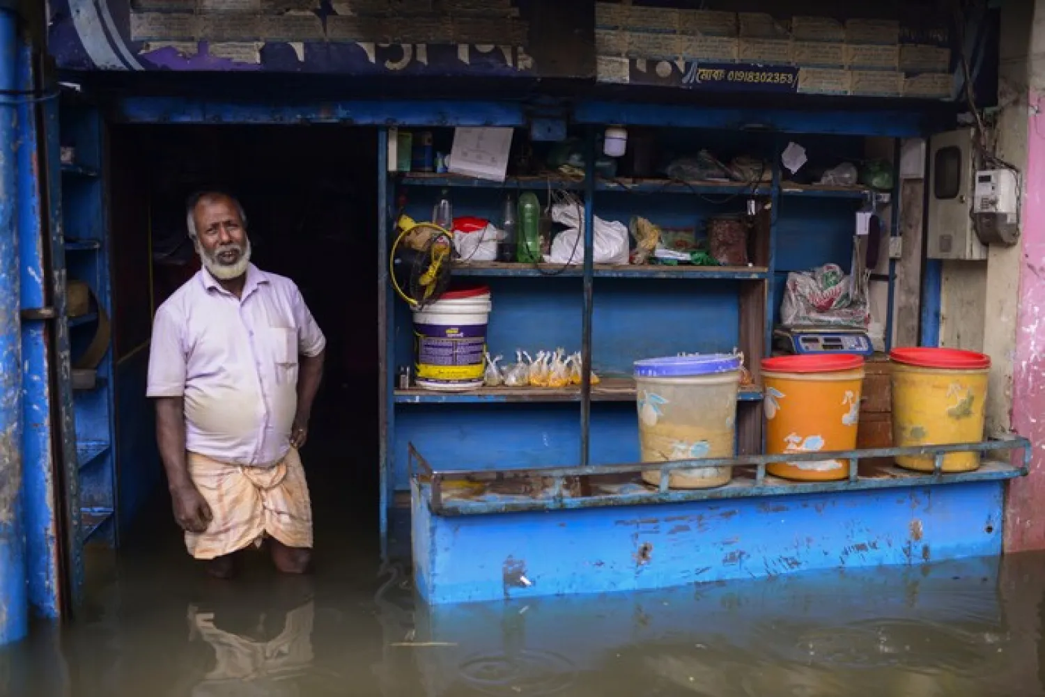 A man stands at the doorway of his flooded shop in Sylhet, Bangladesh, Monday, June 20, 2022. (AP Photo/Mahmud Hossain Opu)

