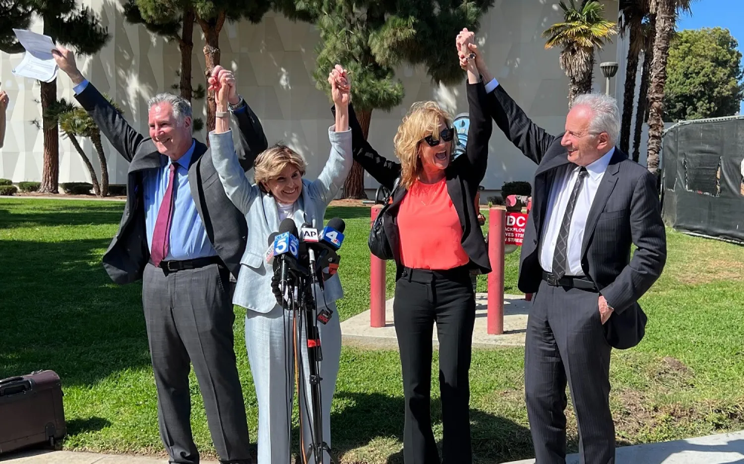 Attorneys John West, from left, Gloria Allred, plaintiff Judy Huth and attorney Nathan Goldberg join arms following a verdict in Huth's favor in a civil trial involving actor Bill Cosby outside the Santa Monica Courthouse on Tuesday, March 21, 2022. (AP)