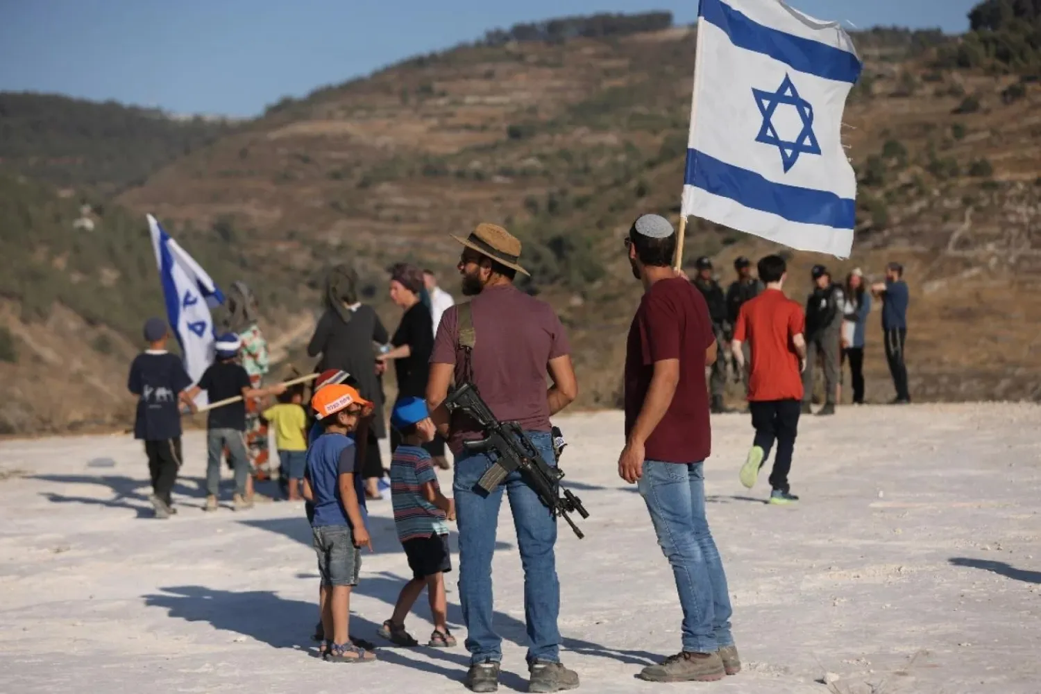 Israeli settlers gather near the settlement of Bat Ayin in the occupied West Bank on 21 June 2021. AFP