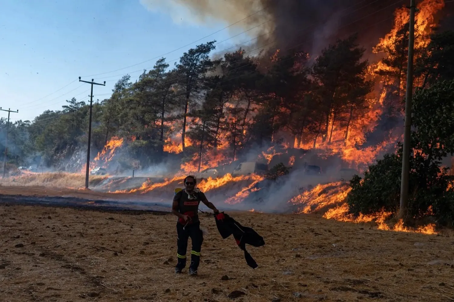 A firefighter walks ahead of a wildfire on August 2, 2021, in Mugla, Marmaris district. (AFP)