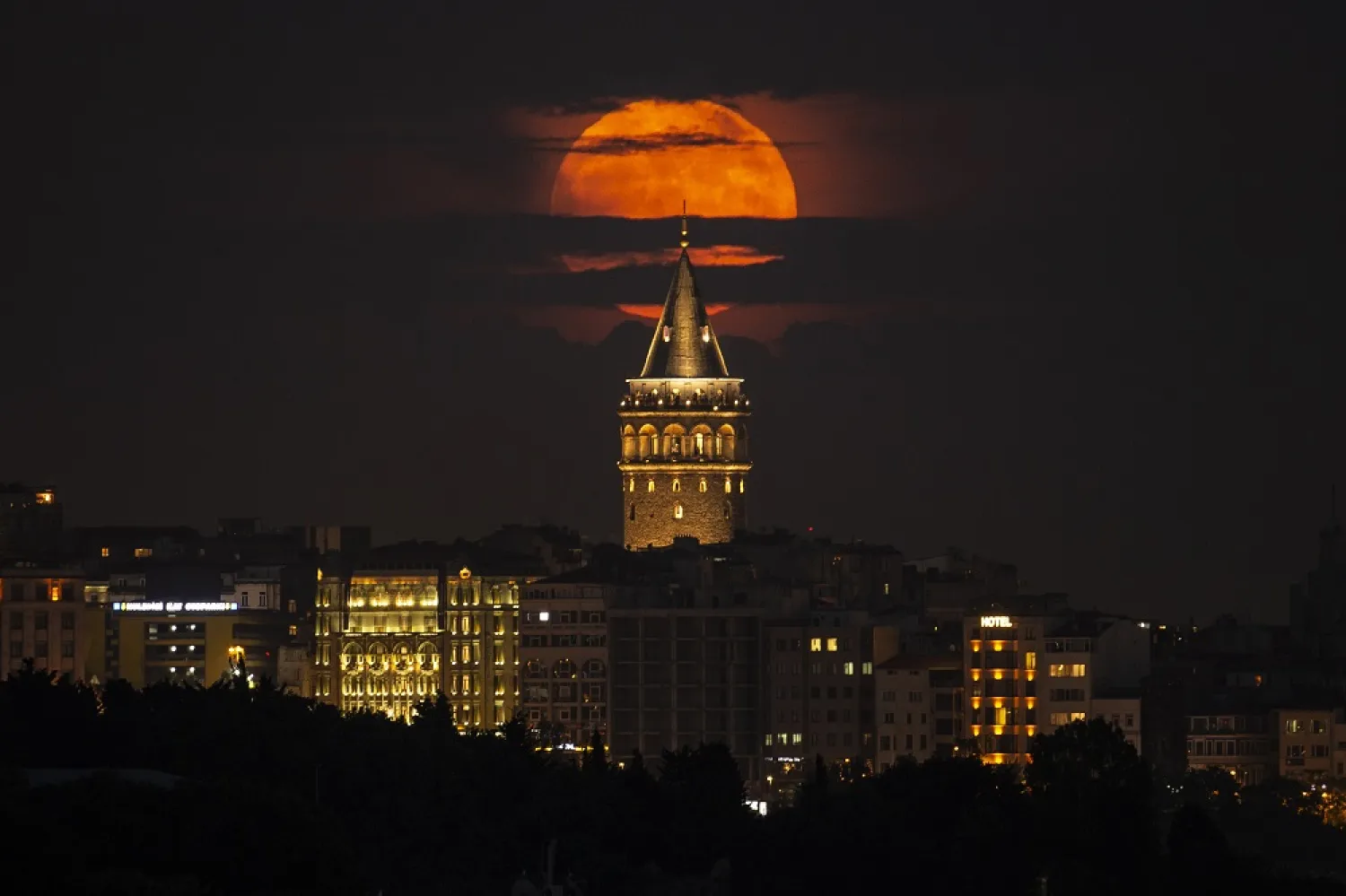 A supermoon rises behind the Galata Tower in Istanbul, Turkey, Tuesday, June 14, 2022. (AP)
