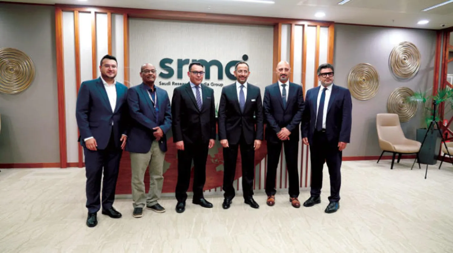 وزير الصناعة السعودي بندر الخريف في صورة تذكارية مع الزملاء في هيئة التحرير (الشرق الأوسط)