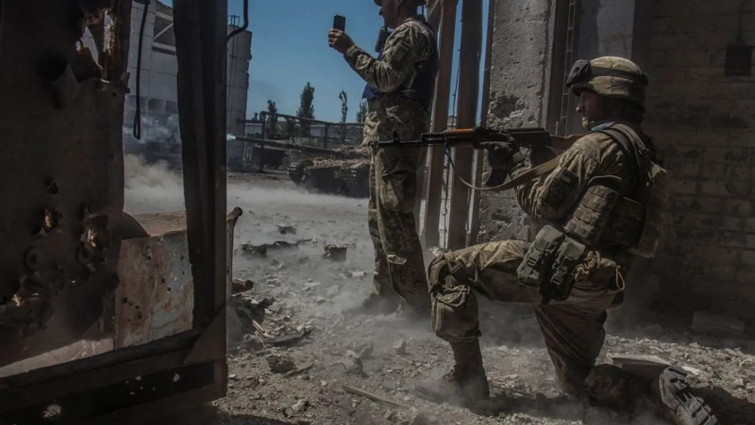 Ukrainian service members watch while a tank fires toward Russian troops in the industrial area of the city of Sievierodonetsk, as Russia's attack on Ukraine continues, Ukraine June 20, 2022. REUTERS/Oleksandr Ratushniak
