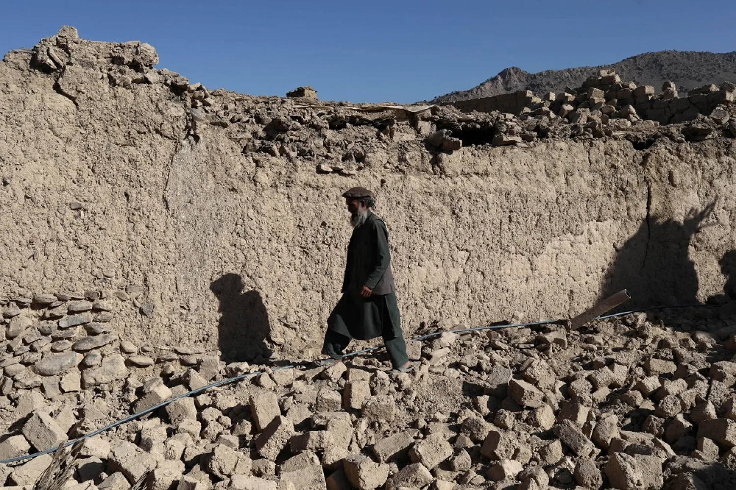 An Afghan man walks past a damaged house after the recent earthquake in Wor Kali village in the Barmal district of Paktika province, Afghanistan, June 25, 2022. (Reuters)