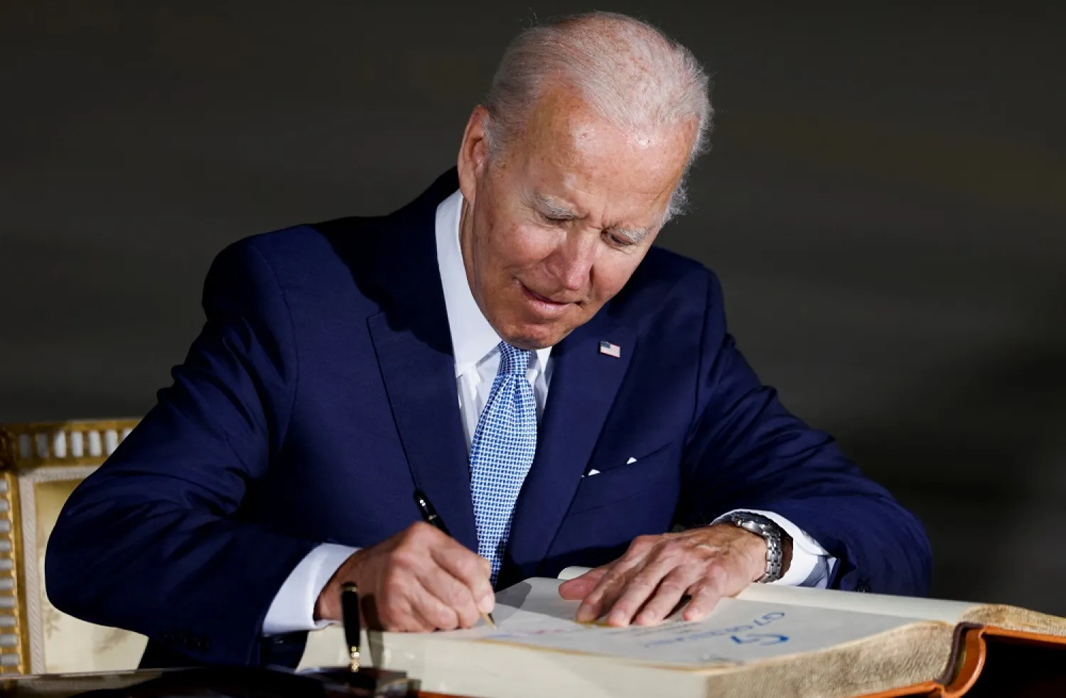 US President Joe Biden signs the Golden Book of the Bavarian State government as he arrives for a G7 summit at Munich International Airport near Munich, Germany June 25, 2022. (Reuters)